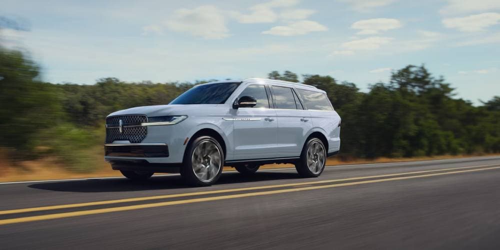 white 2027 lincoln navigator driving on road