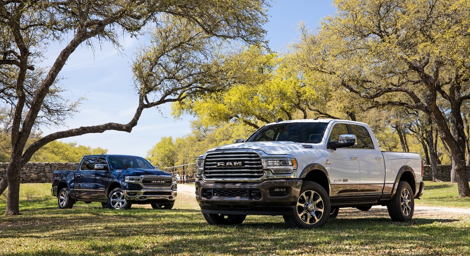 blue and white Ram 2500 trucks parked under a tree