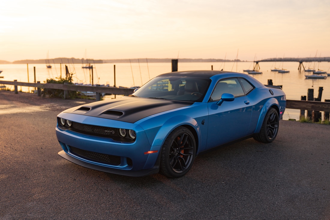 blue Dodge Challenger Hellcat Coupe parked on a beach pier