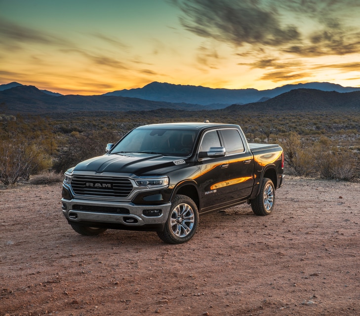 black Ram 1500 truck parked in front of a desert sunset