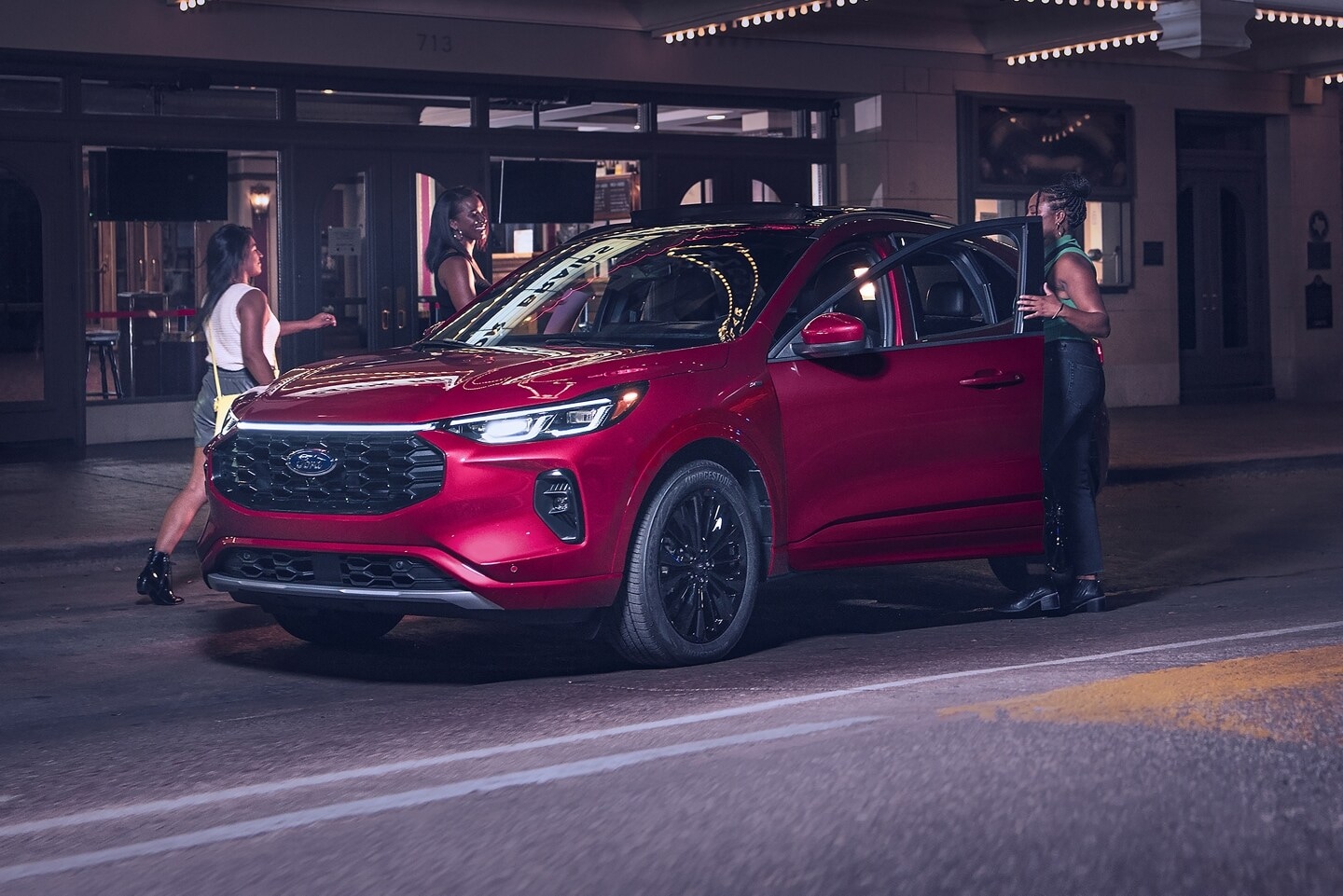 Women and a red Ford Escape SUV