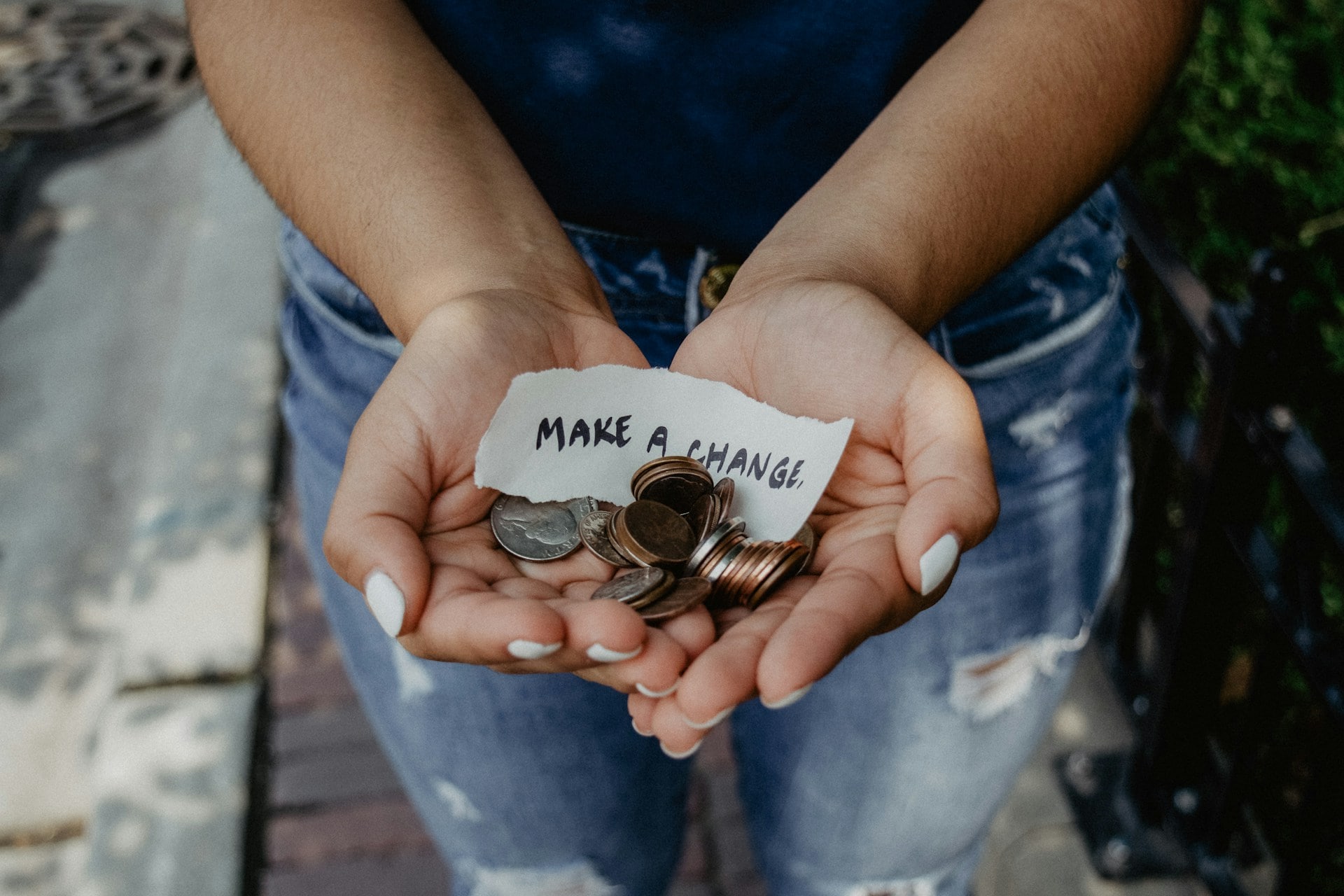 Hands holding change and a note that says Make a Change