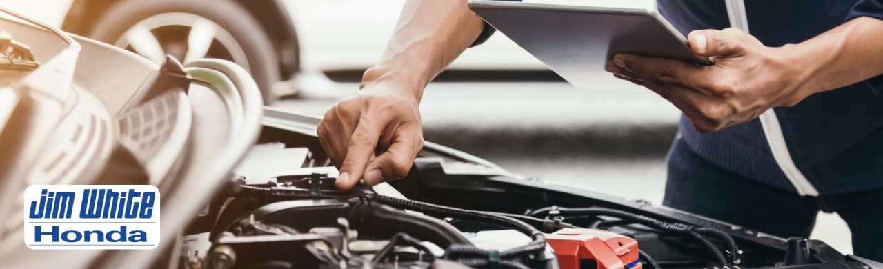Honda technician installing replacement Honda brakes using genuine Honda OEM parts at Jim White Honda serving Toledo, OH.