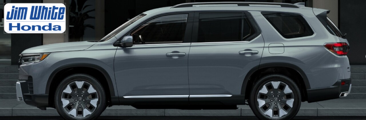 Front view of the 2026 Honda Pilot TrailSport parked in a rugged terrain setting near Toledo, showcasing off-road design.