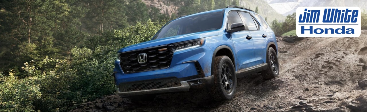 2025 Honda Pilot parked near a Toledo neighborhood showcasing its bold front grille and 3-row family design