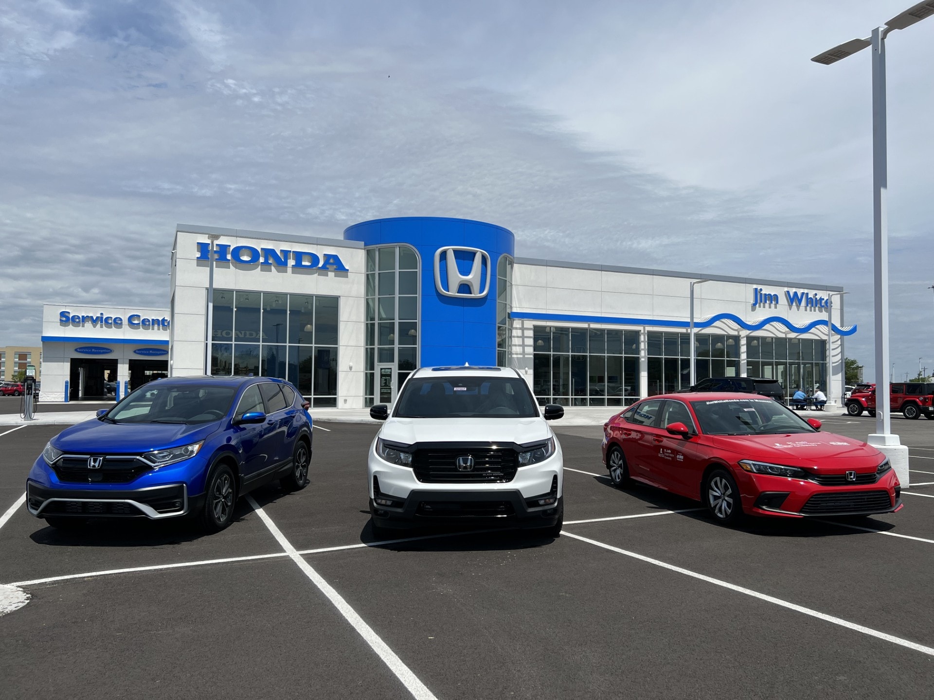  Honda sales representative explaining current lease specials to a customer in the Jim White Honda showroom in Toledo, OH