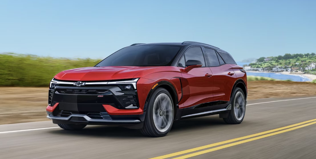 Red 2026 Chevrolet Blazer EV driving fast on highway.