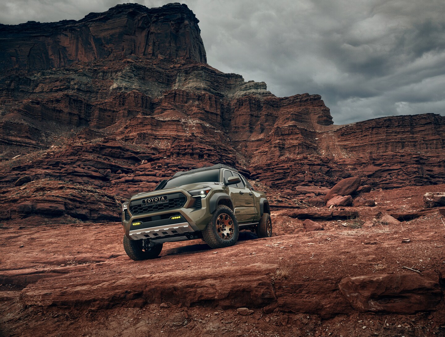 Green Toyota Tacoma in rugged terrain