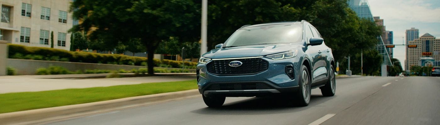 Blue 2026 Ford Escape driving on a city 
street