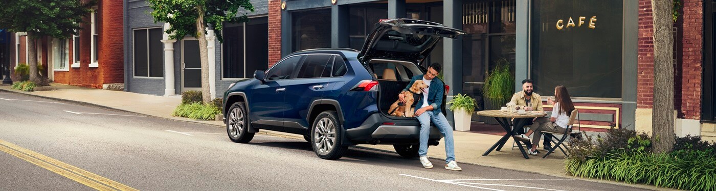 Blue Toyota RAV4 Limited parked in a town with its trunk open