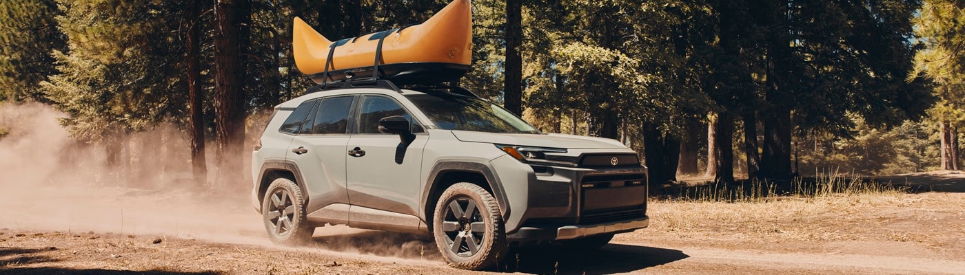 Green Toyota RAV4 Woodland driving on a dirt road in the forest