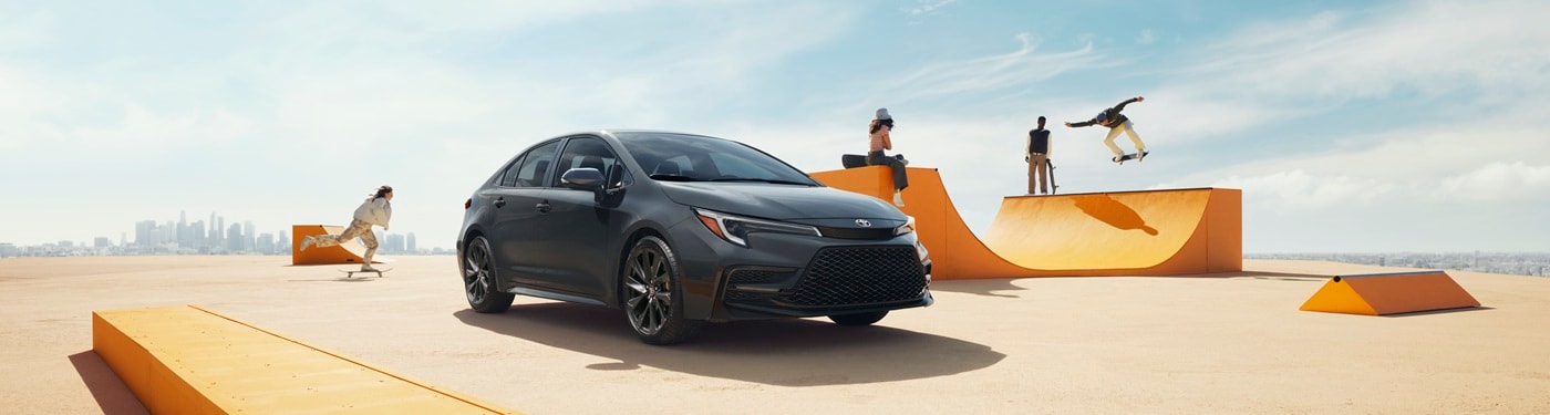 Black Toyota Corolla SE parked by a skatepark