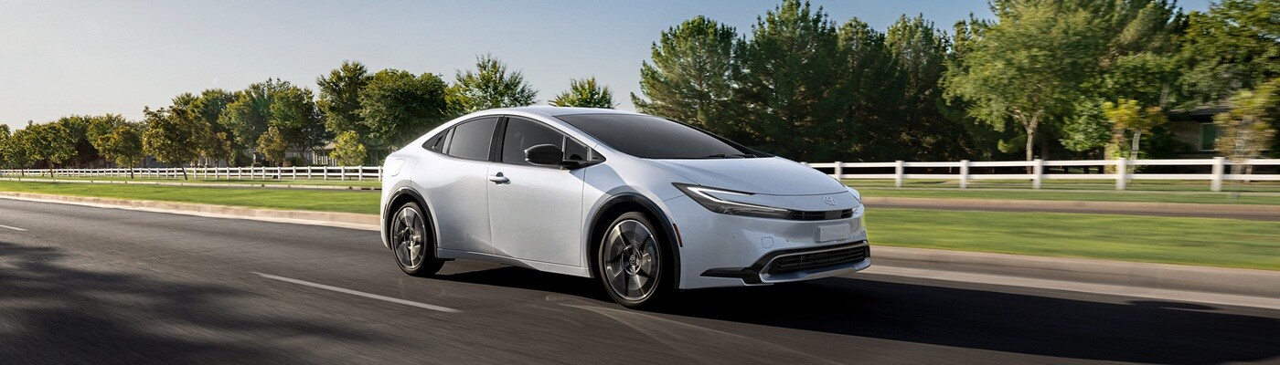 White Toyota Prius PHEV XSE Premium driving in a suburb