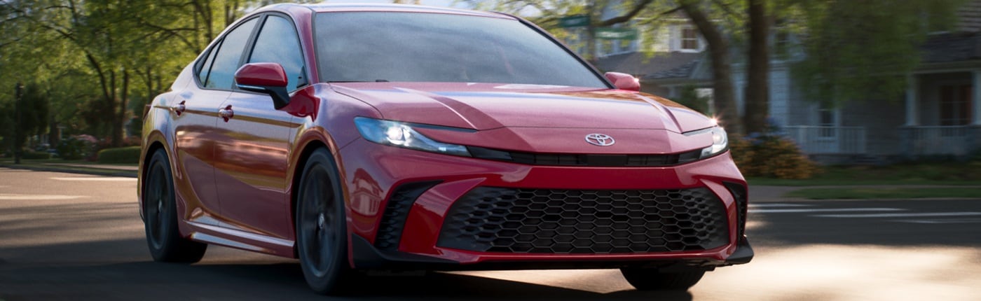 Red Toyota Camry SE driving in the suburbs