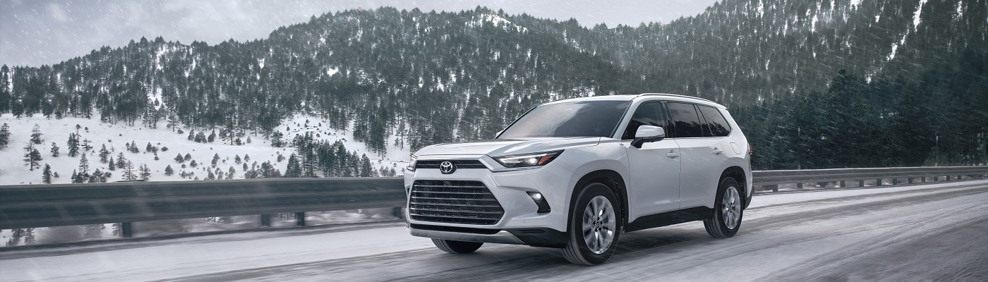 White Toyota Grand Highlander Platinum driving thru the snow