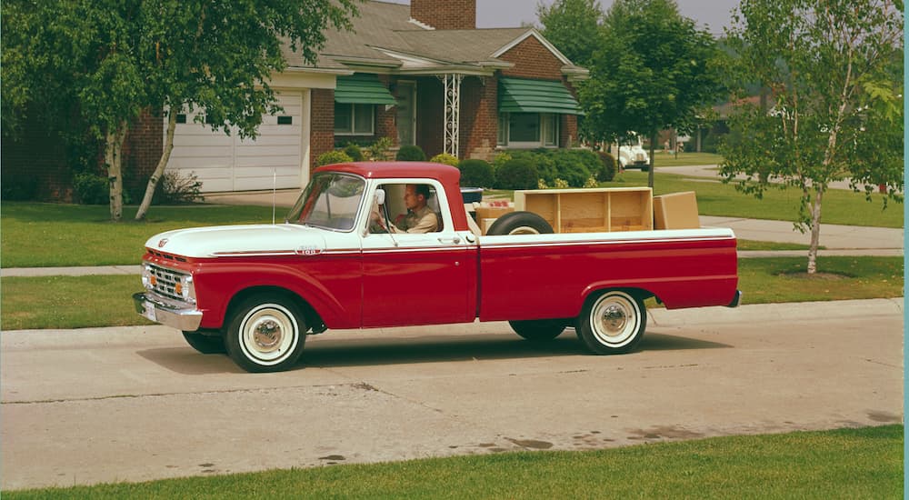 Ford Dealer Near You - 1964 Ford F-100 - House.jpg A red and white 1964 F-100 is shown from the side parked in front of a house.