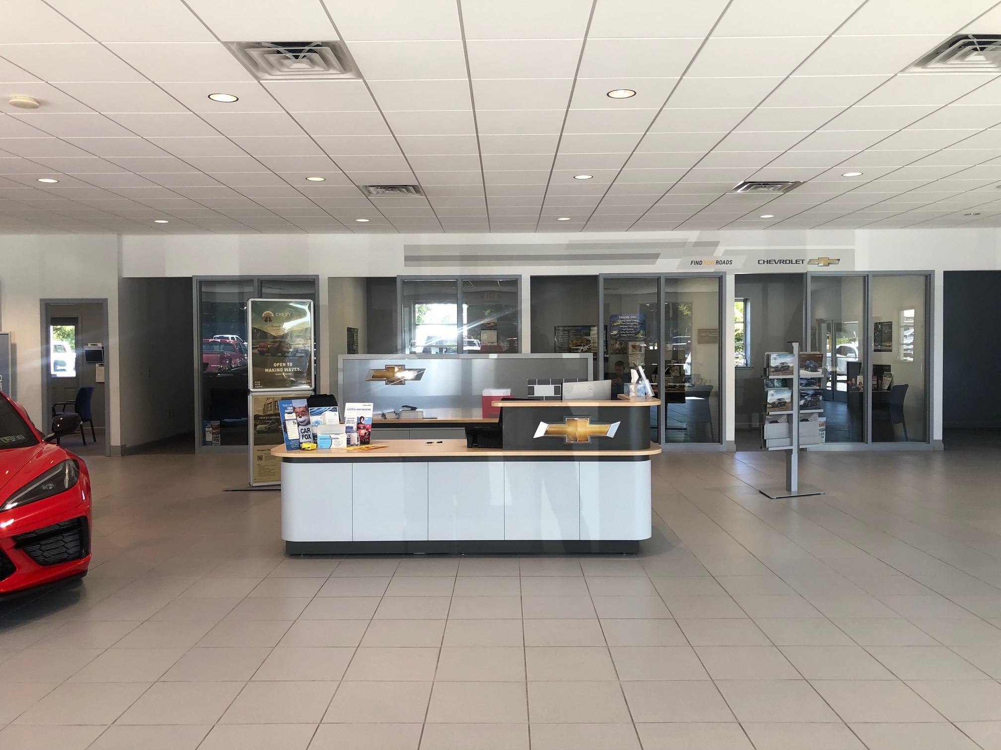 Dealership employee smiling shaking hands with satisfied customer.