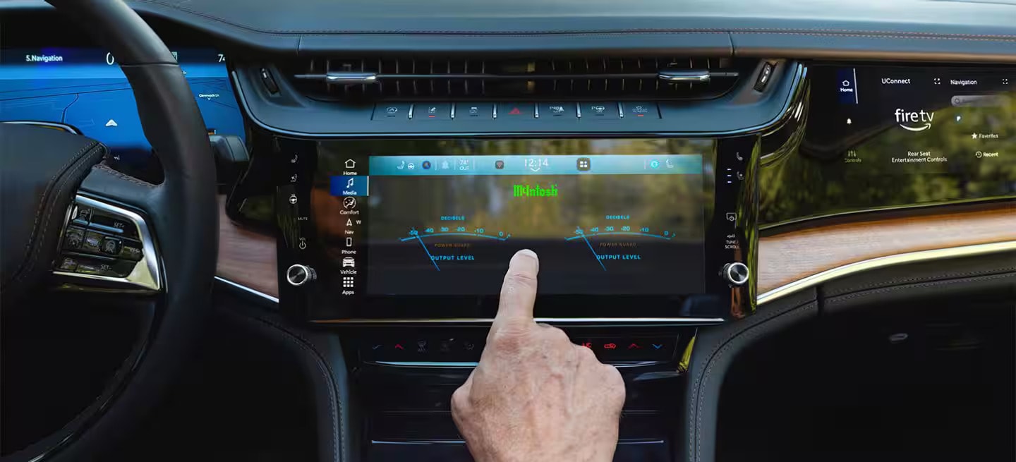 A person using the front display screen in a jeep grand cherokee.
