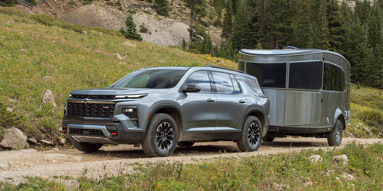 A chevy traverse pulling a trailer off-road.