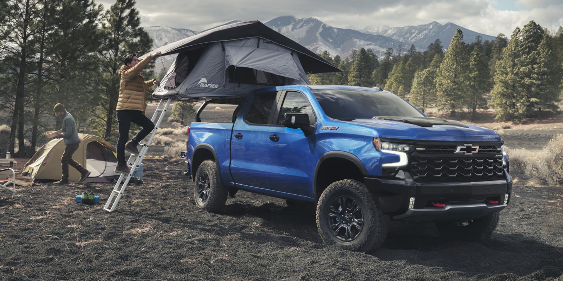 a view of the 2026 chevy Silverado 1500 parked at a camp site utilizing the bed