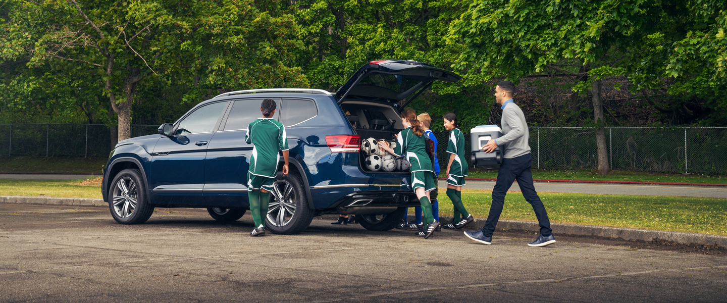 Soccer team storing their equiqment inside a blue Volkswagen vehicle