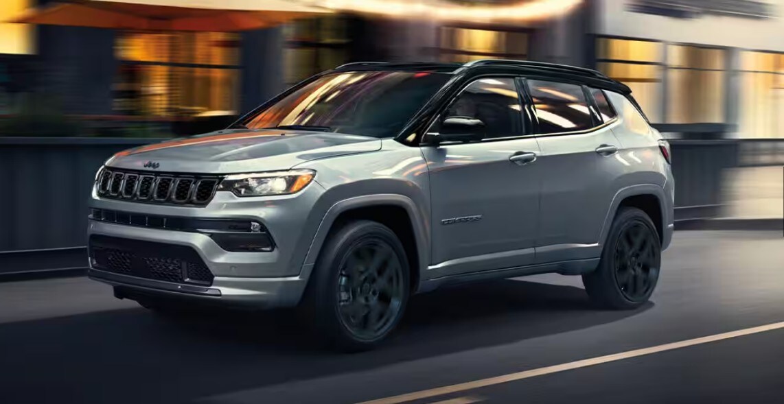 Silver 2025 Jeep Compass driving fast though a city