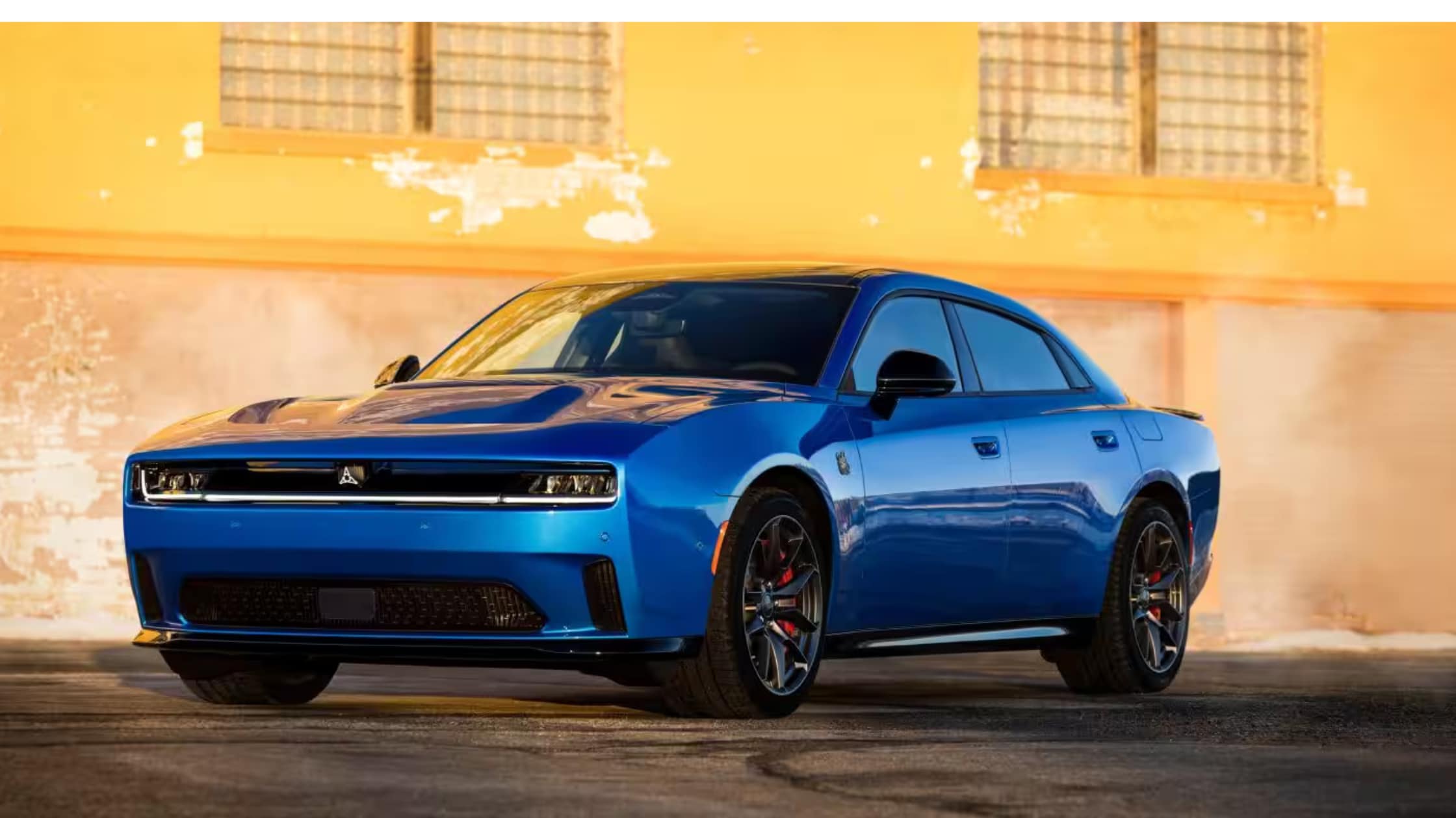 A Blue Electric 2026 Dodge Charger Daytona looking cool in front of a burning building
