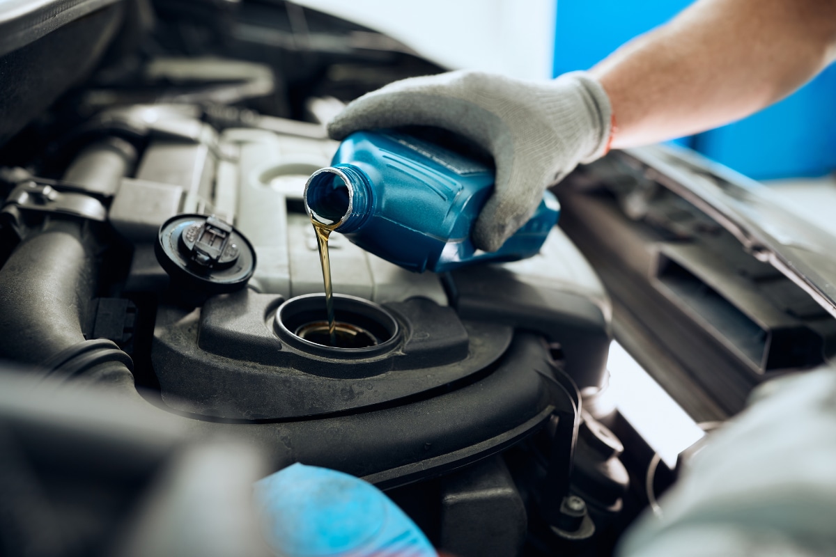 Close up of a technician performing an oil change Close up of a technician performing an oil change