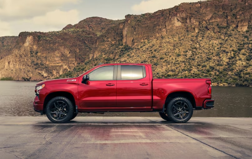 Red 2024 Chevy Silverado 1500 parked on concrete next to a pond Red 2024 Chevy Silverado 1500 parked on concrete next to a pond