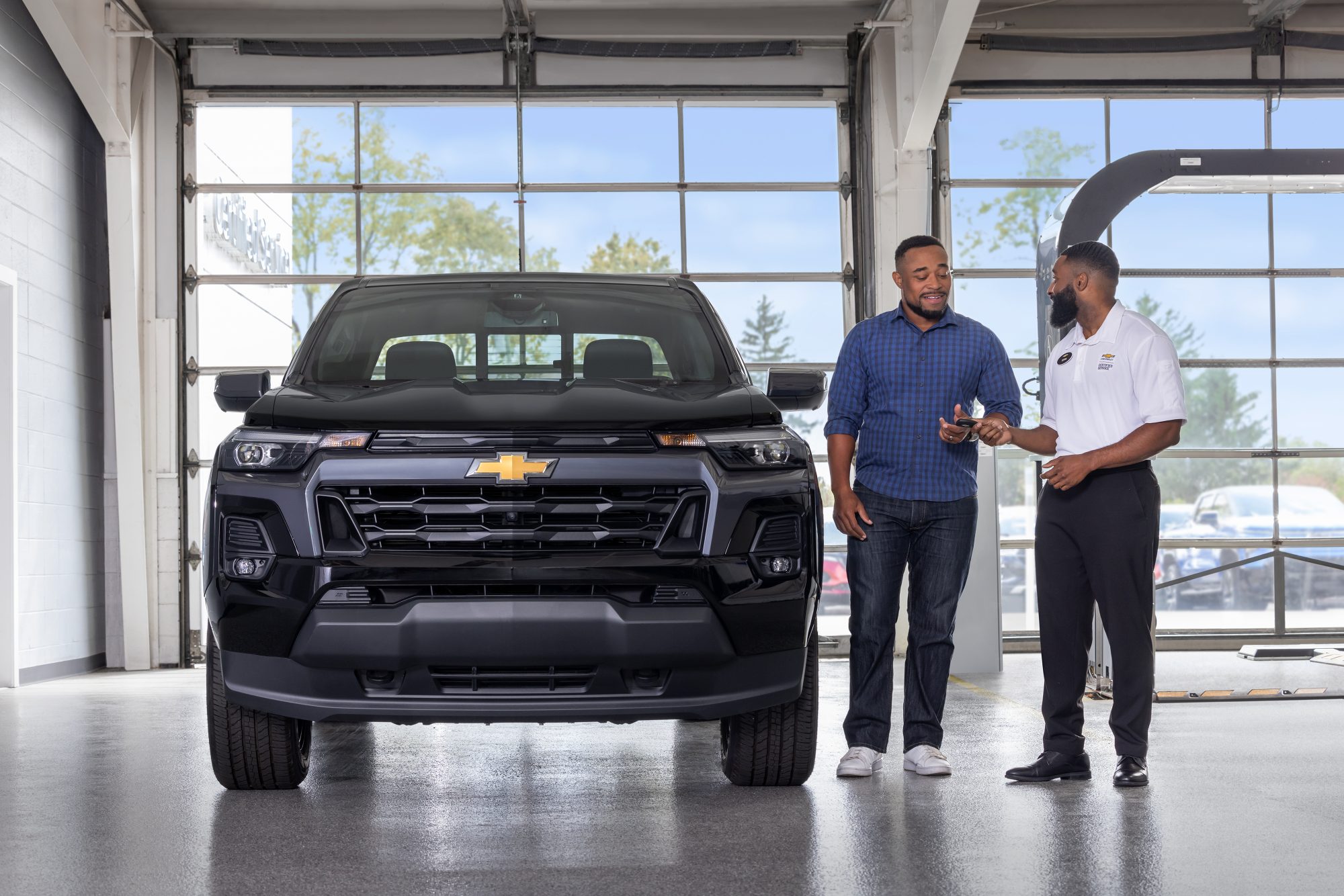 Two people in chevrolet dealer speaking