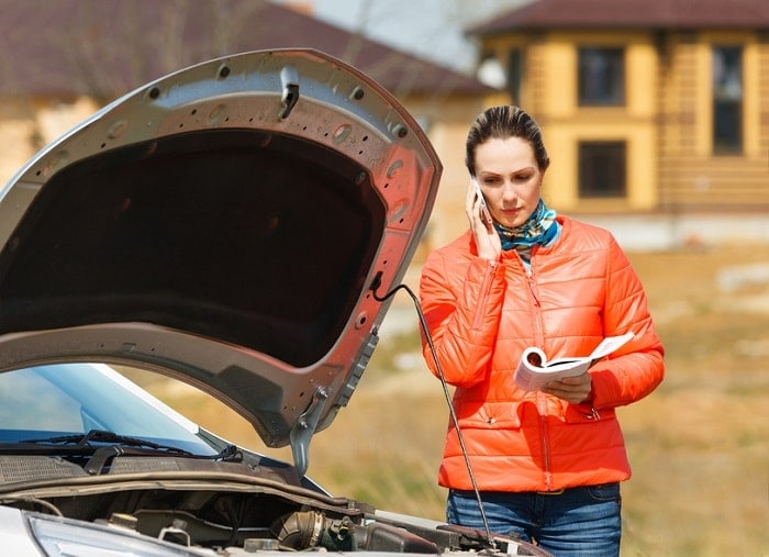 Girl_Looking_At_Service_Manual_By_Car.jpg