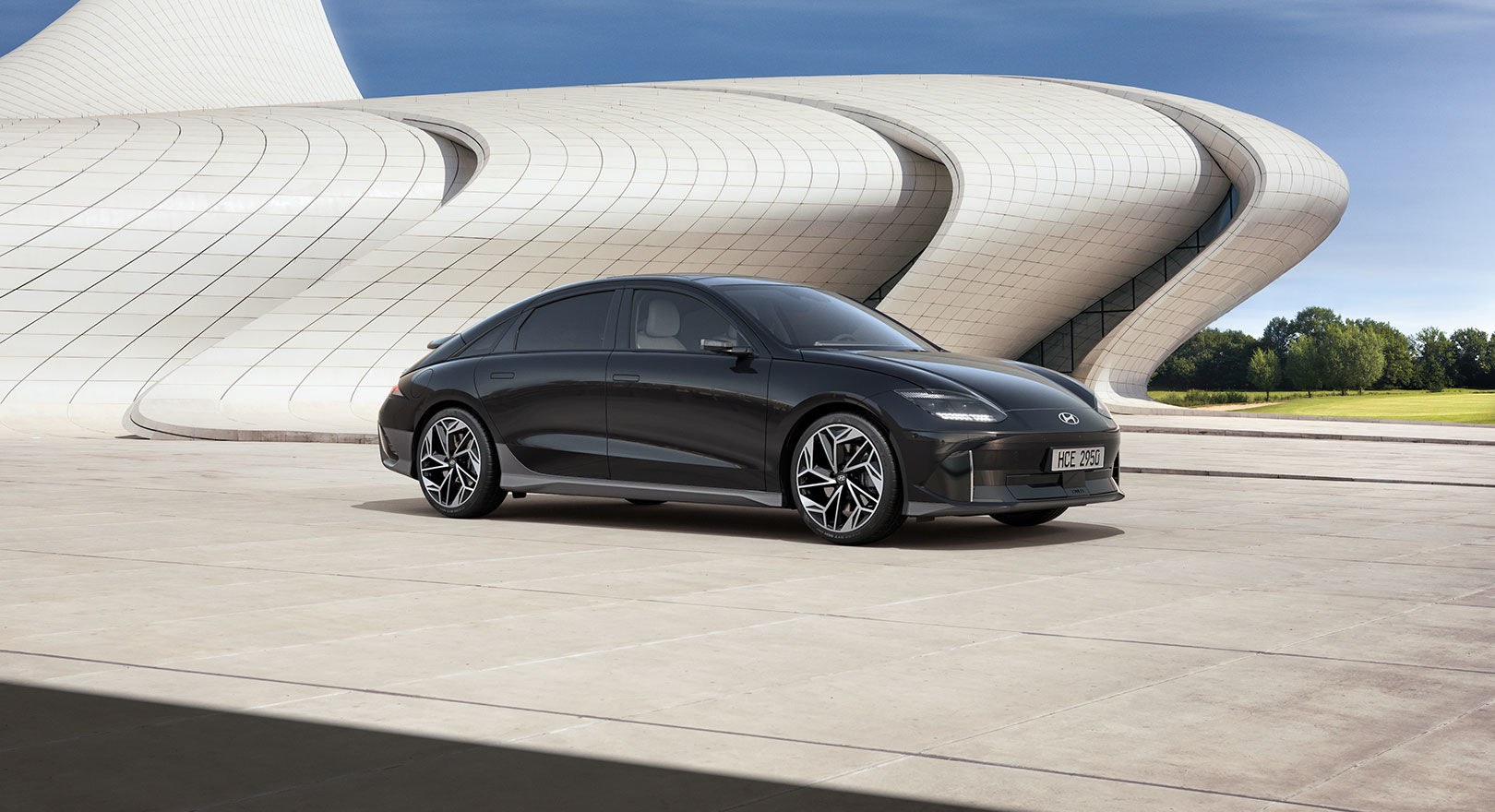 black Hyundai Ioniq 6 SUV parked next to a large modern sculpture