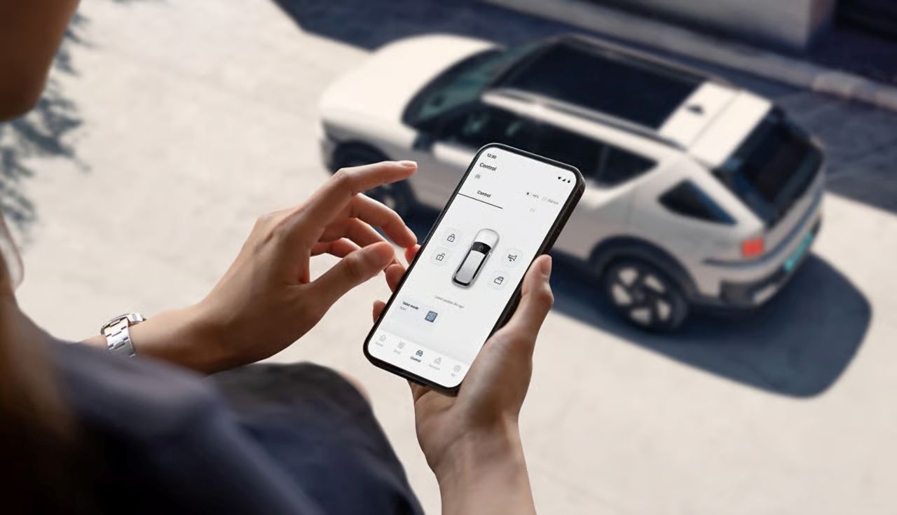 phone running Hyundai app in front of Hyundai car