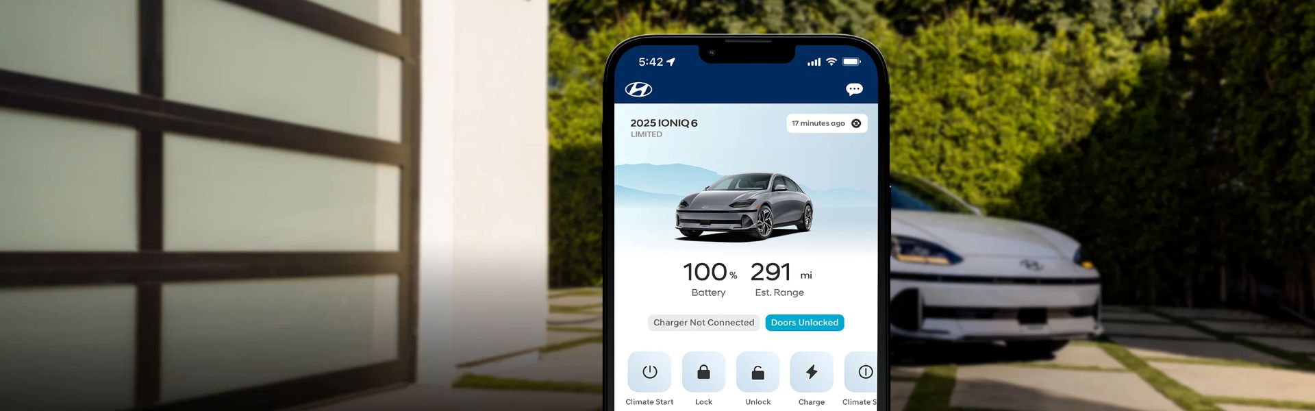 Phone with Bluelink app in front of car in driveway