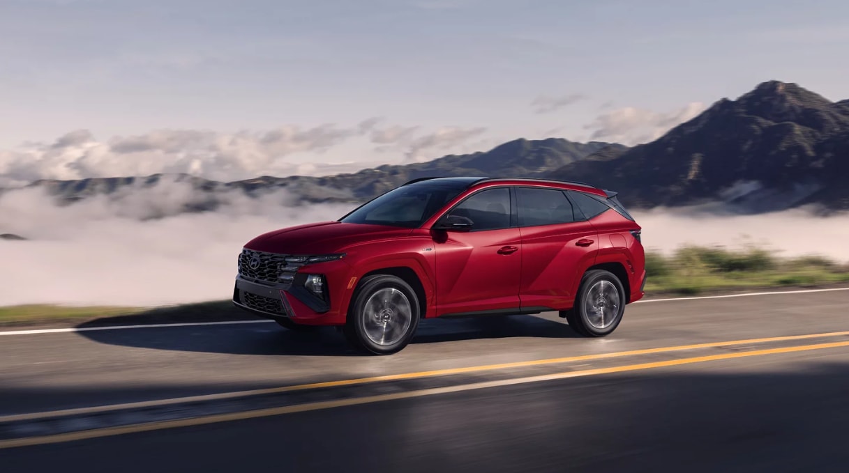 Side view of the 2025 Hyundai Tucson Hybrid driving on a mountain Side view of the 2025 Hyundai Tucson Hybrid driving on a mountain