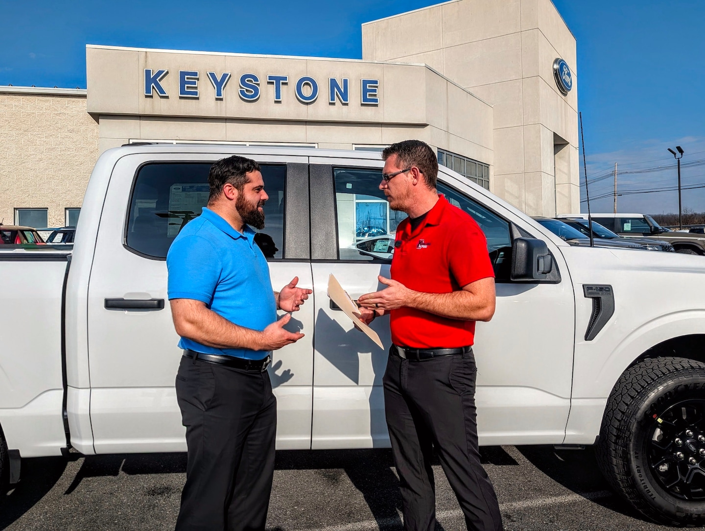  Exterior shot of man in front of house with a white Explorer® SUV cell phone in hand