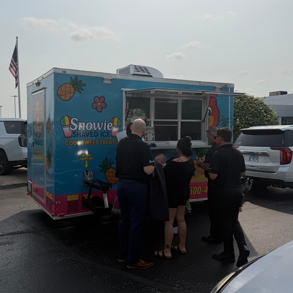 Snowie Ice serving refreshments to families during the Cars and Cuts event in McHenry