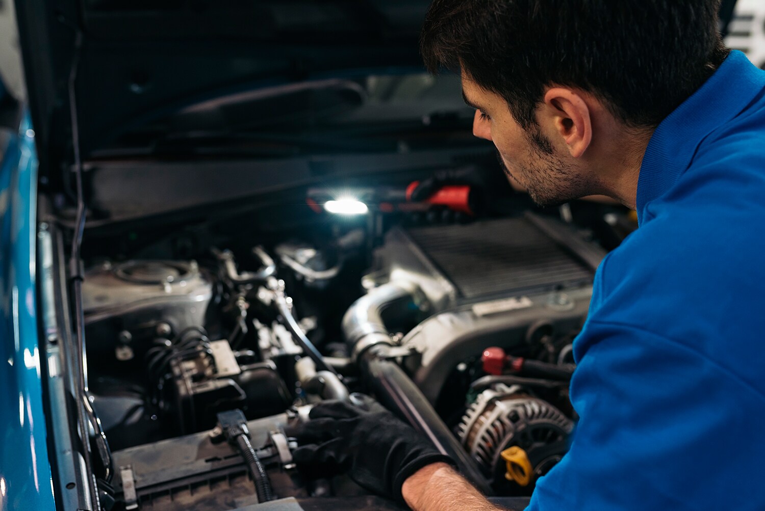 Kia Oil Change Benefits at Kia of New Bern | Service technician inspecting engine