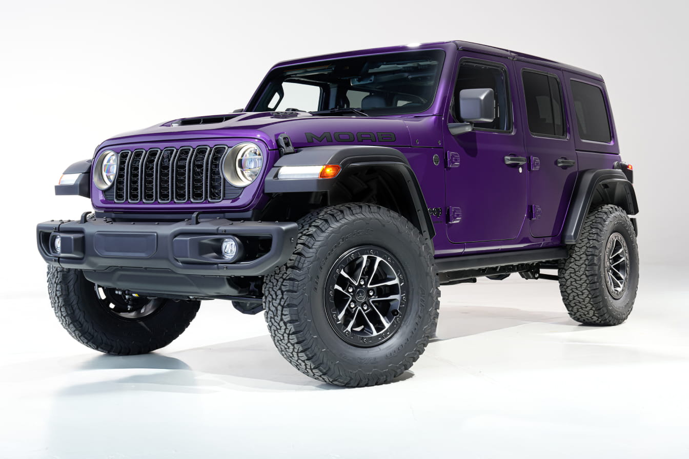 2026 Jeep Wrangler with black accents on large tires, against a white background. The vehicle exudes a rugged, adventurous vibe.