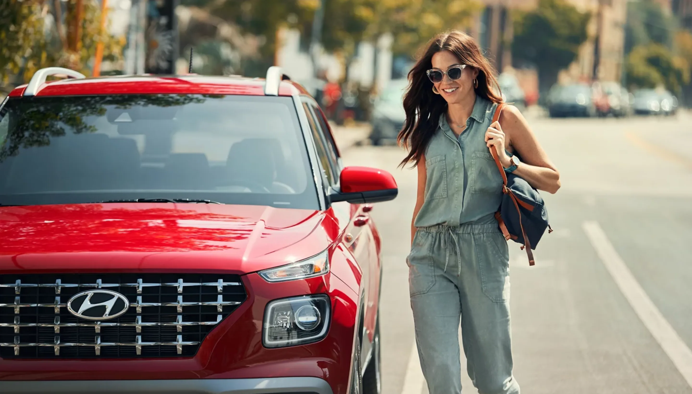 College student walking to her red 2026 Hyundai Venue