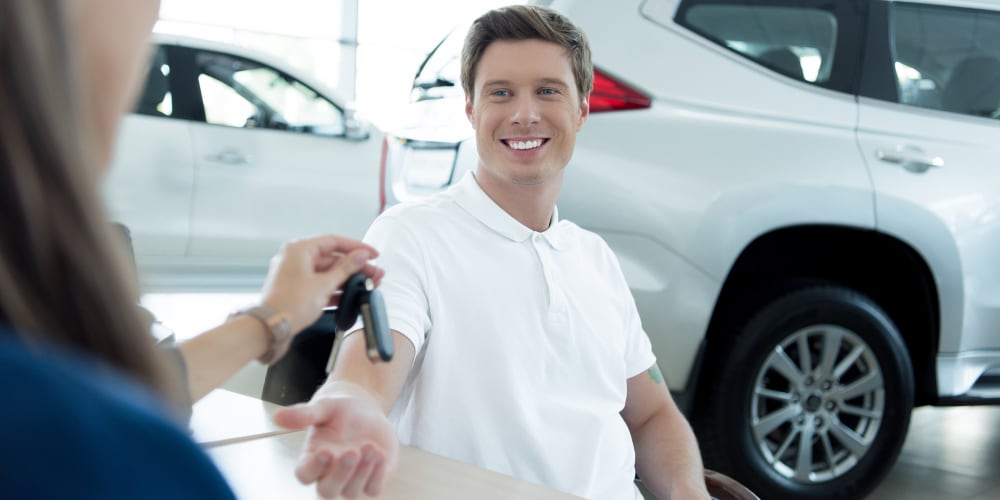 Salesperson handing over car keys to a customer