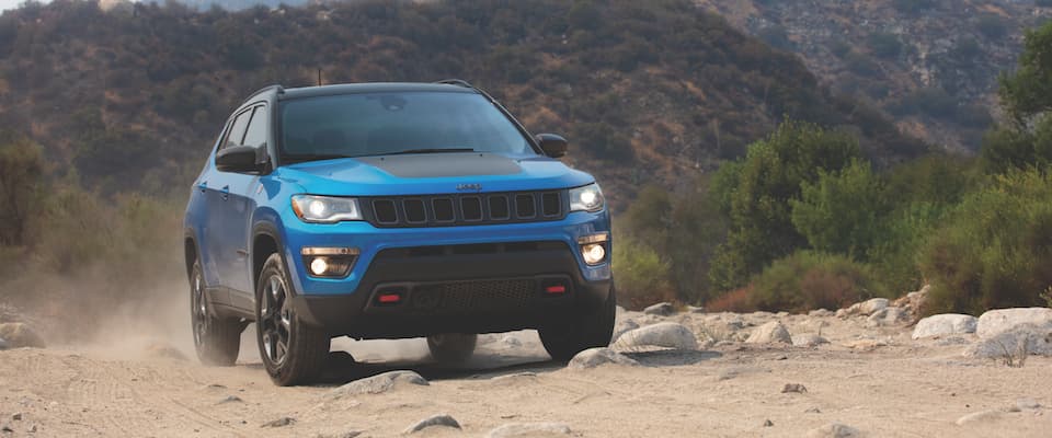 2019 Jeep Compass A blue 2019 Jeep Compass offroading over a rocky path