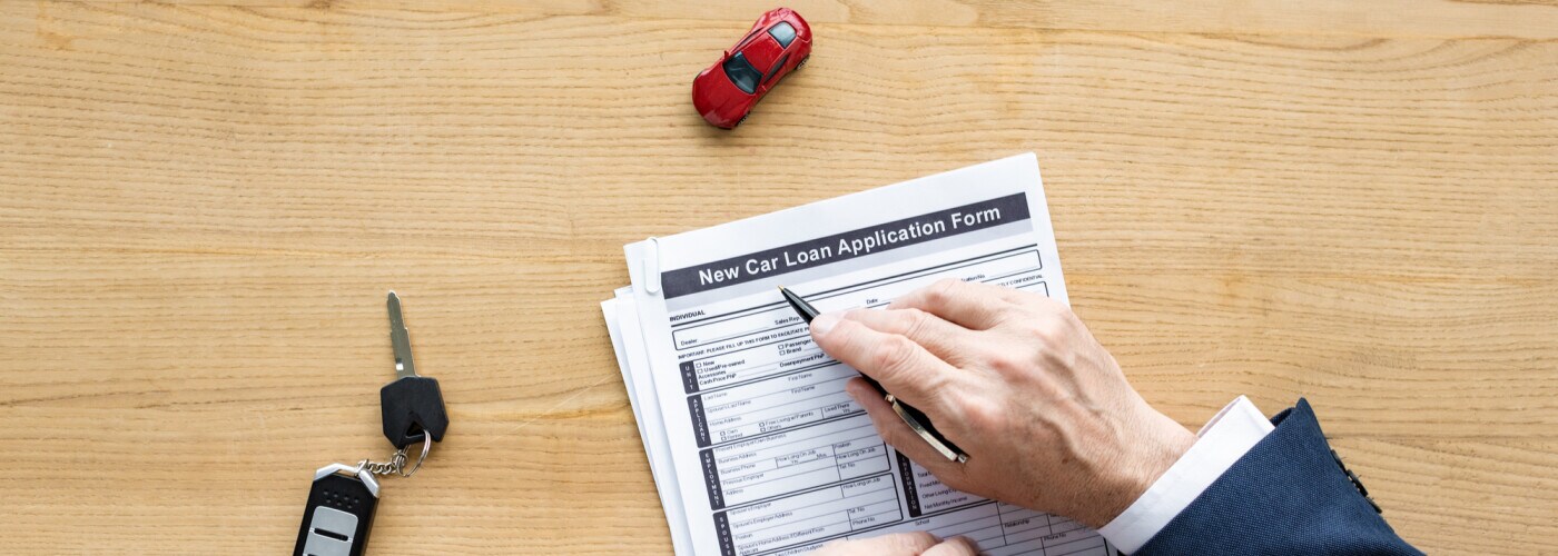 Man signing car loan paperwork