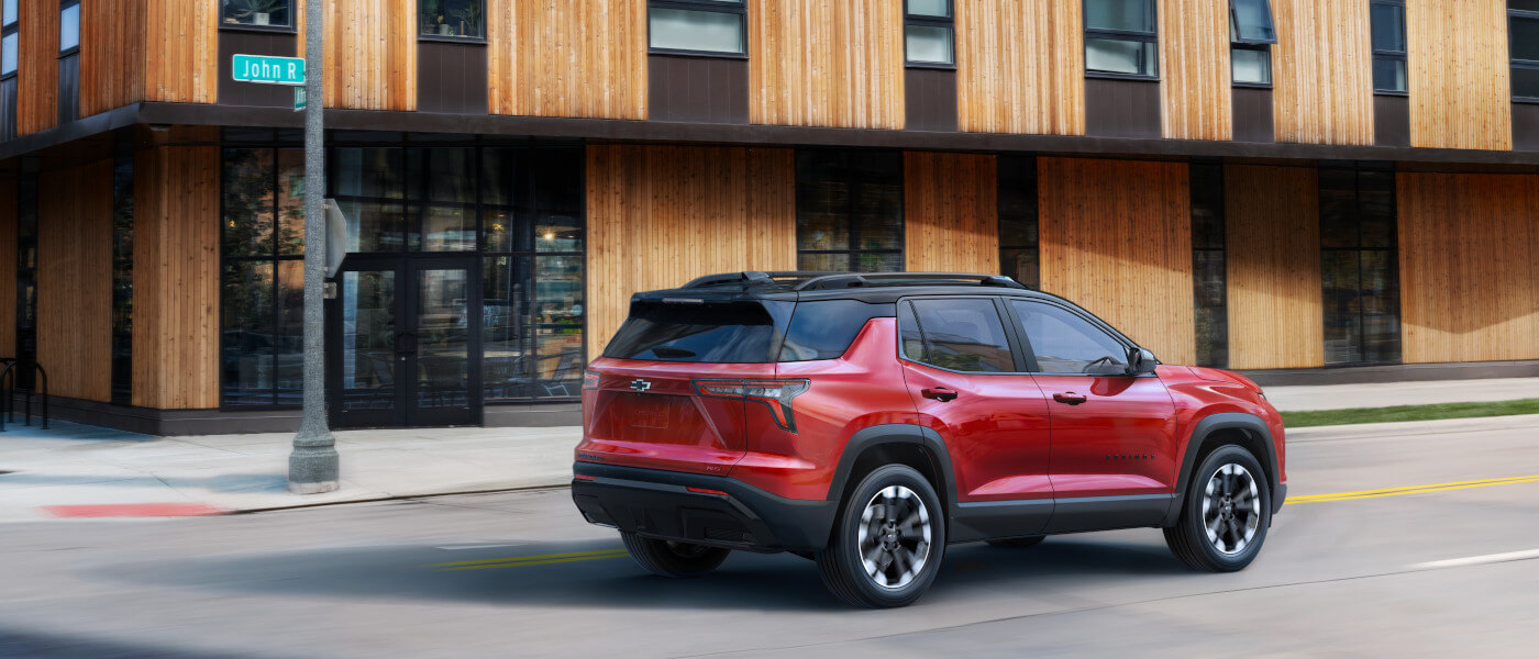 2027Chevy-Equinox-ExteriorDrivingPastWoodenOfficeBuilding
