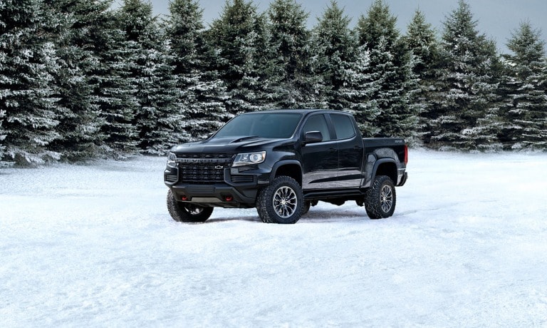 2022 Chevrolet Colorado Parked in a snowy field surrounded by evergreen trees