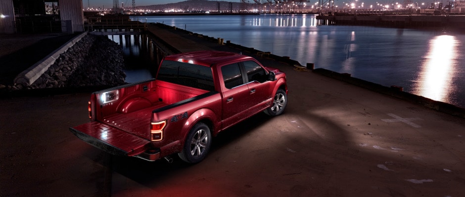 A red 2018 Ford F-150 parked at night