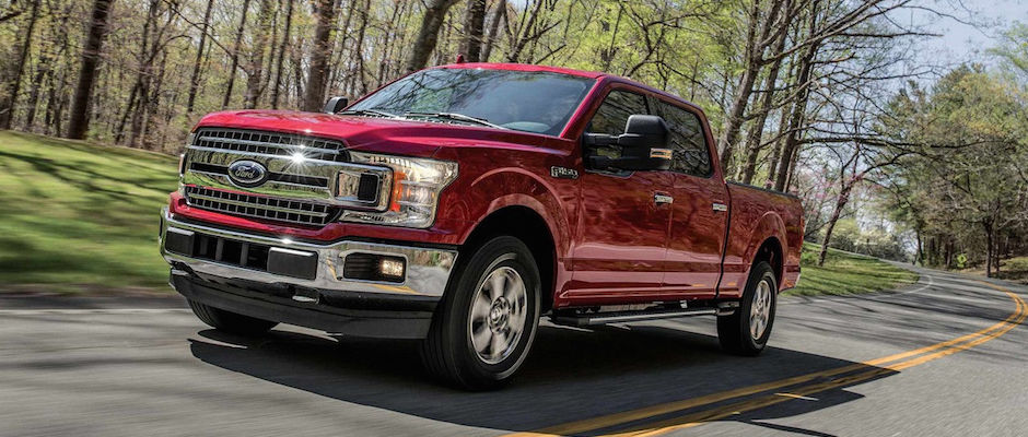 A red 2018 Ford F-150 driving down an open road