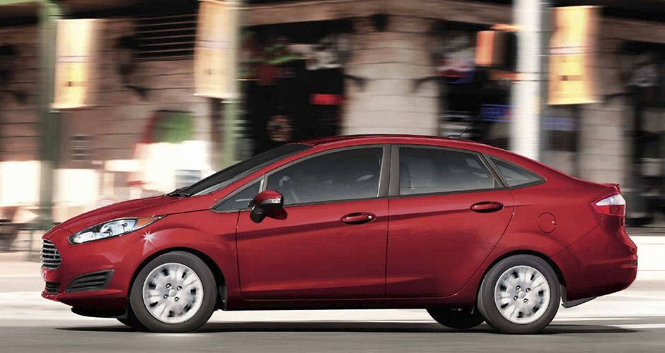A red 2017 Ford Fiesta driving in the city