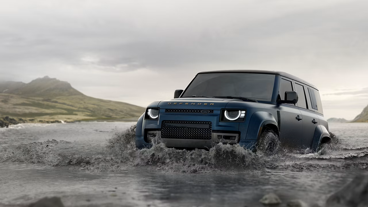 Blue Land rover driving through water