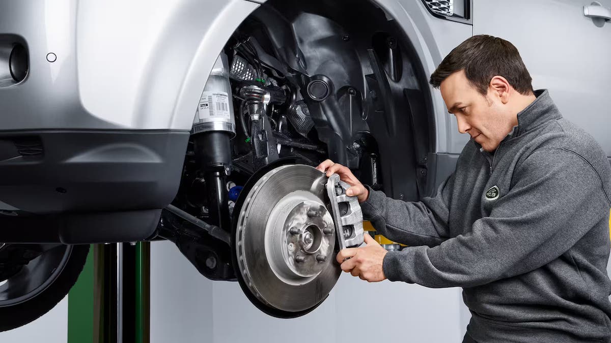 Technician fixing the brakes on a Range Rover vehicle